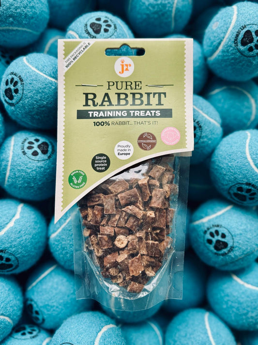 Package of Pure Rabbit training treats on a background of blue tennis balls