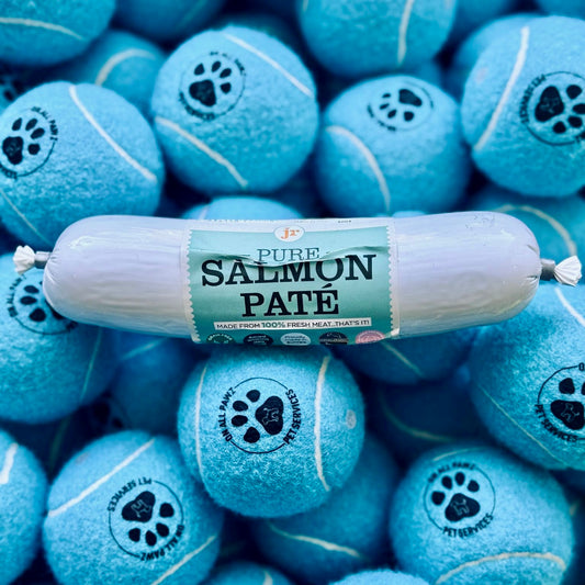 Roll of salmon pate with blue tennis ball-shaped treats in the background