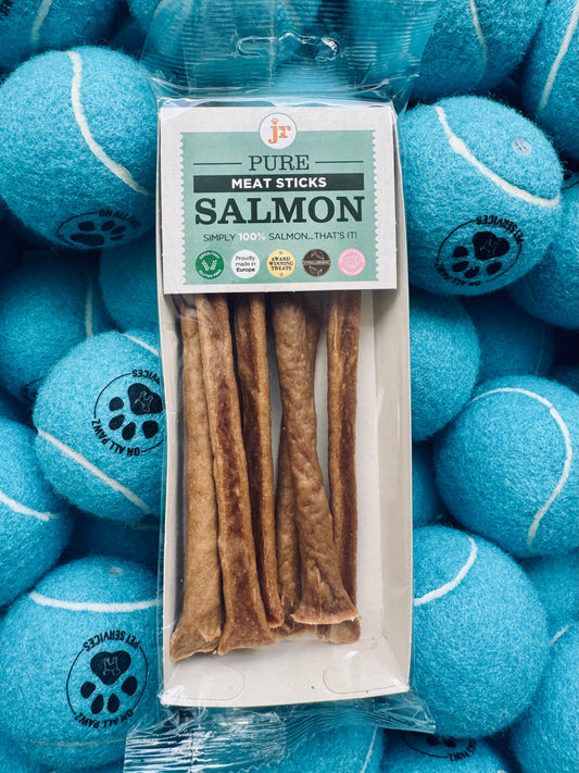 Package of Pure Meat Sticks Salmon treats surrounded by blue tennis balls