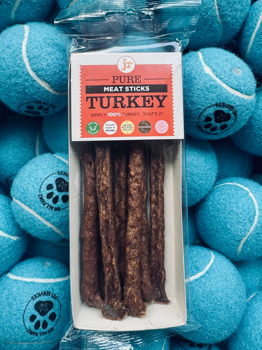 Package of turkey meat sticks with a background of blue tennis balls.