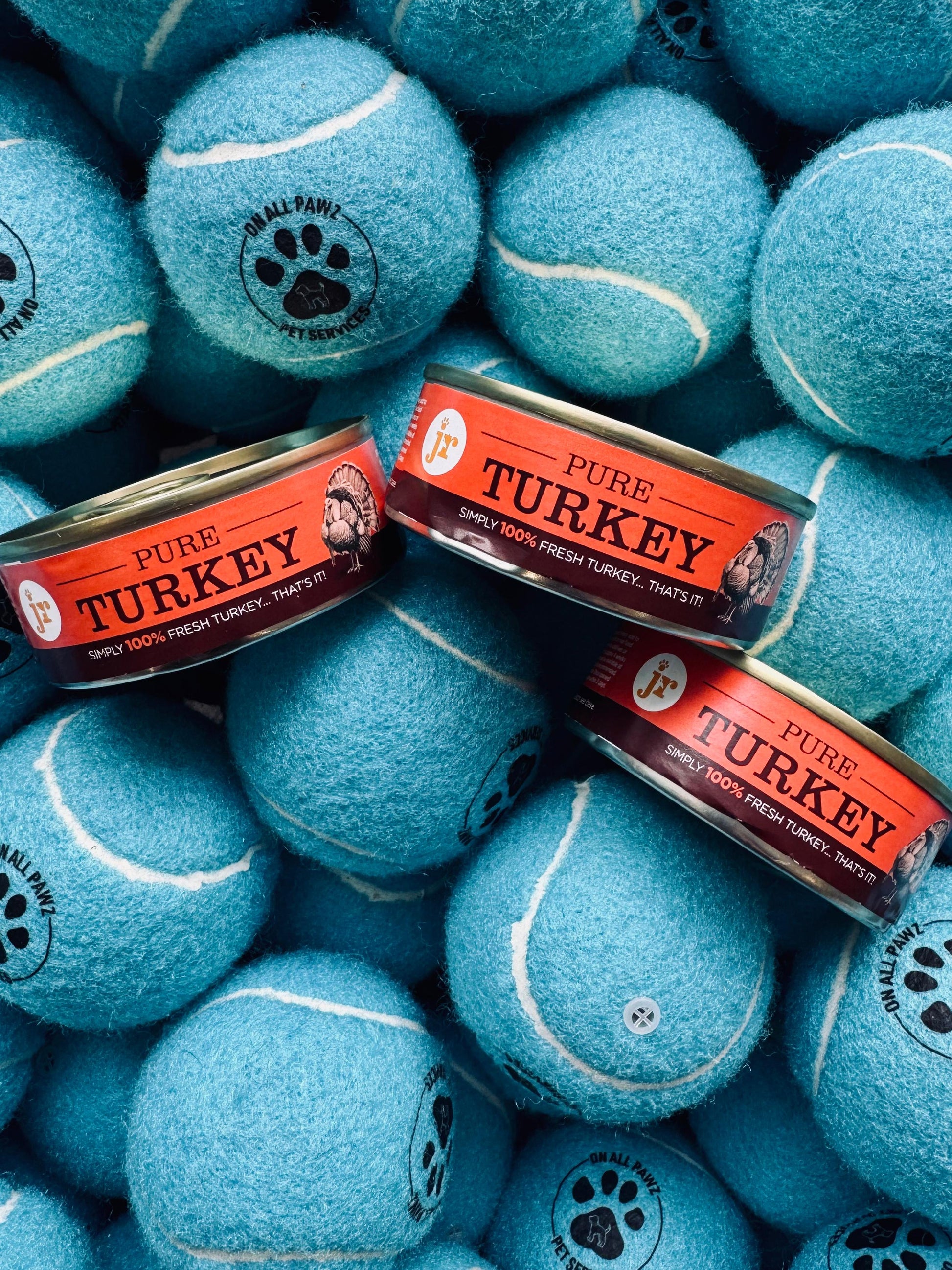 Blue tennis balls with 'Pure Turkey' labels on a pile