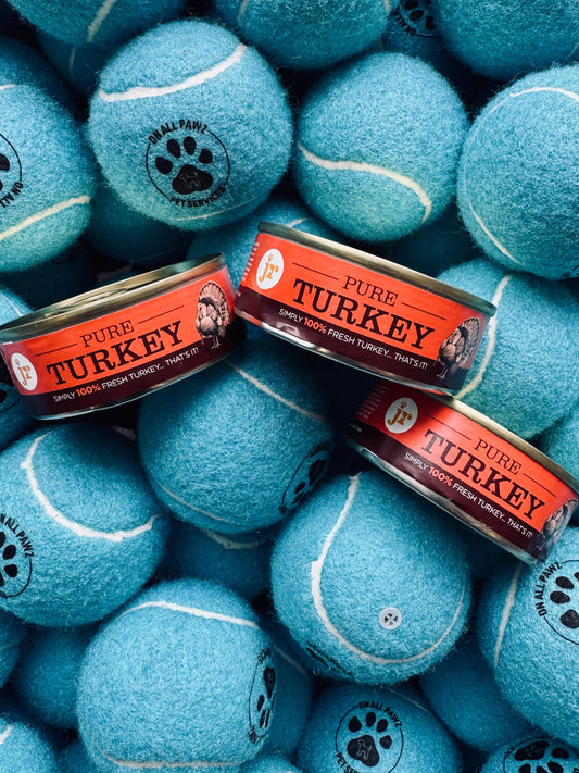 Blue tennis balls with 'Pure Turkey' labels on a pile