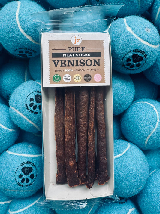 Pack of venison meat sticks with packaging label on a background of blue tennis balls.
