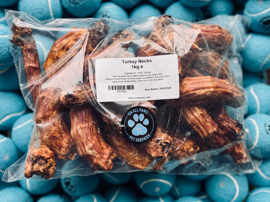 Packaged turkey necks dog treats on a background of blue dog food balls.