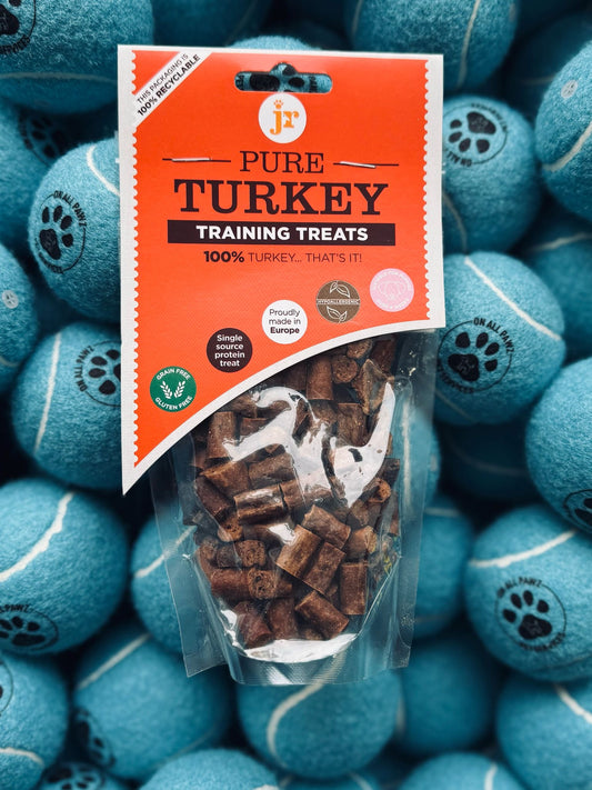 Package of Pure Turkey training treats on a background of blue tennis balls