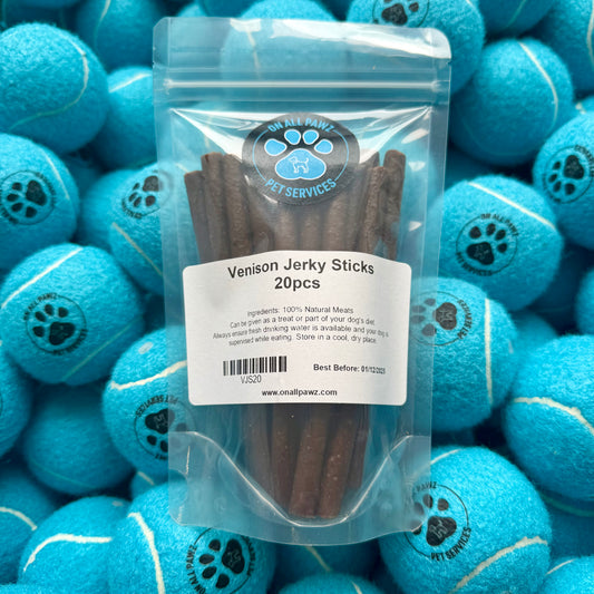 Pack of Venison Jerky Sticks with a label on a background of blue tennis balls.