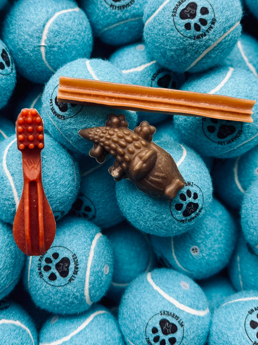 A variety of Whimzees dental chews for small dogs, including bone-shaped and other fun shapes, displayed on a blue background.